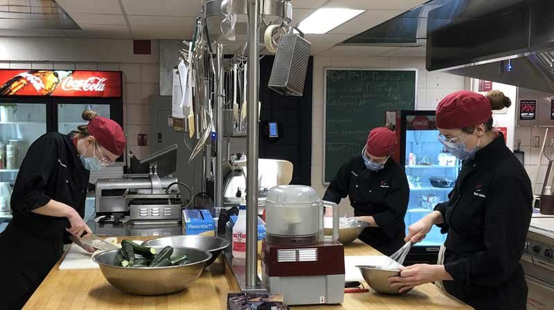 Étudiants en restauration au travail dans la cuisine de la cafétéria