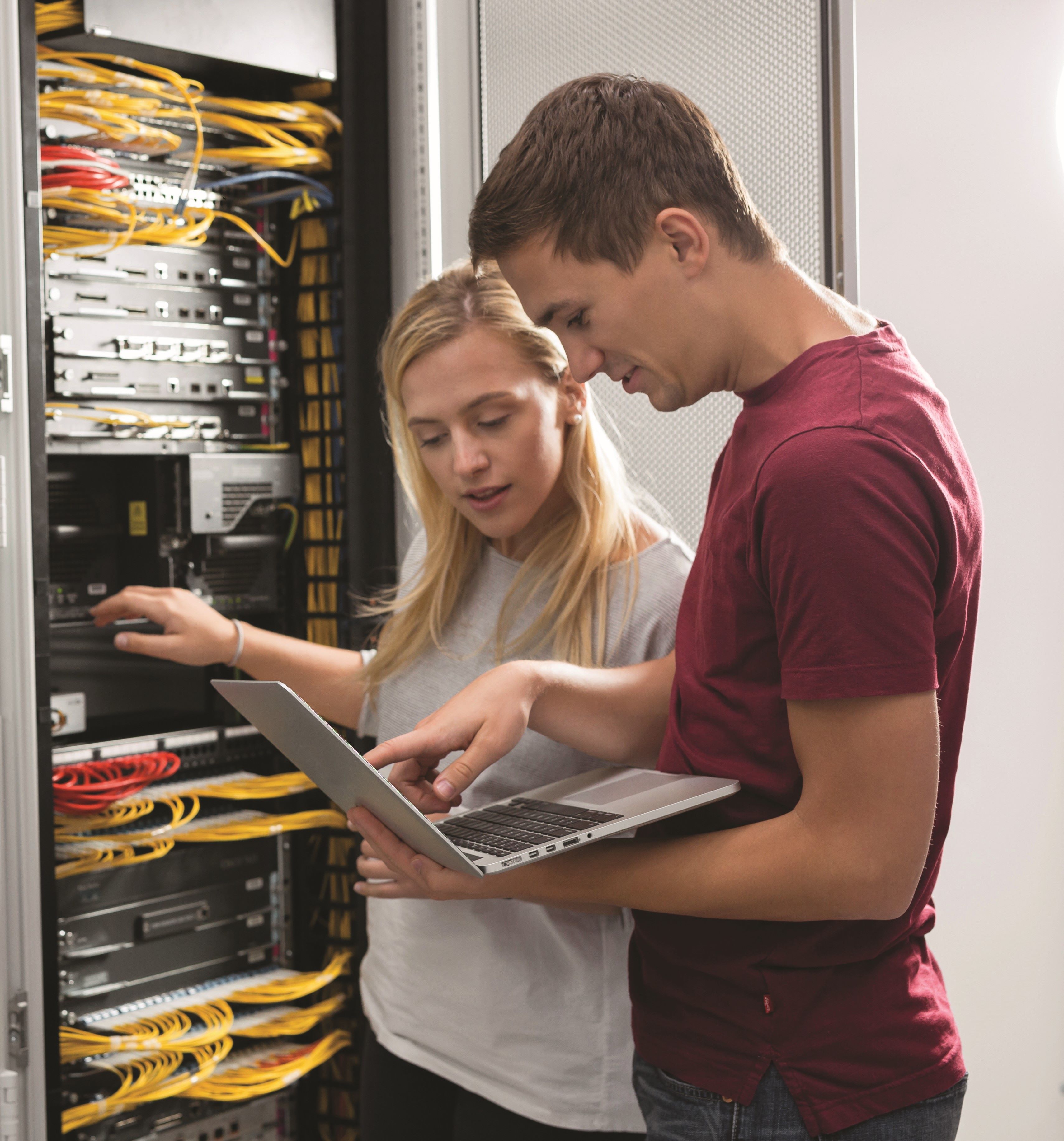 Deux personnes devant des serveurs informatiques