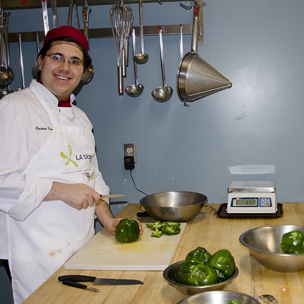 Étudiant souriant dans un laboratoire de cuisine