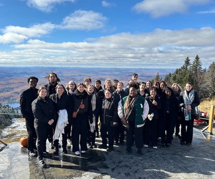 Les étudiant en haut d'une montagne qui regardent la caméra. 