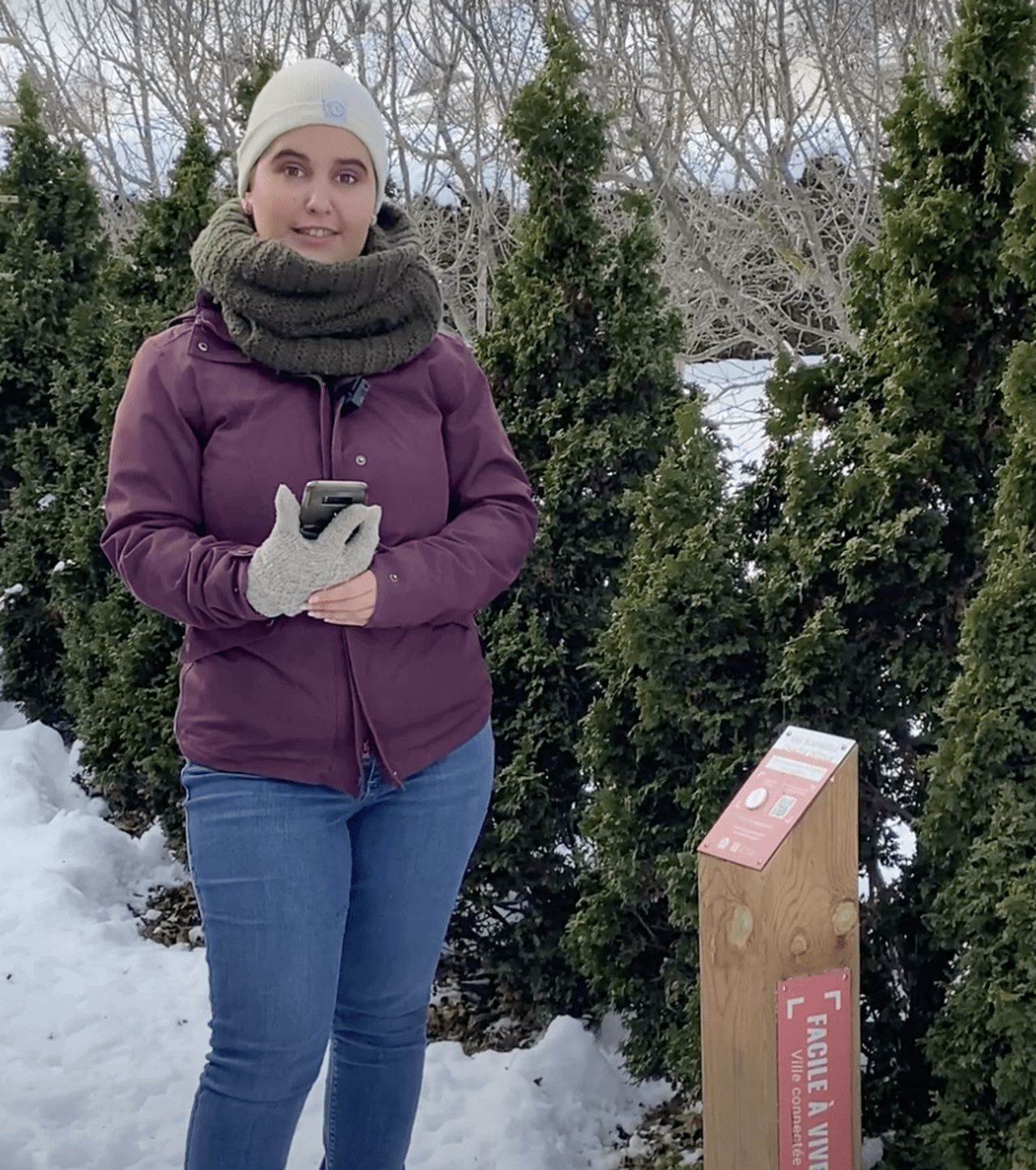 Angélique Paquet devant une borne interactive et des arbres, dans la neige