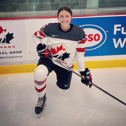 Rosalie Breton, souriante en uniforme sur la glace avec son bâton de hockey