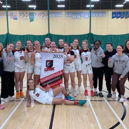 Les joueuses sont alignées sur le terrain de volleyball et sourient à la caméra.