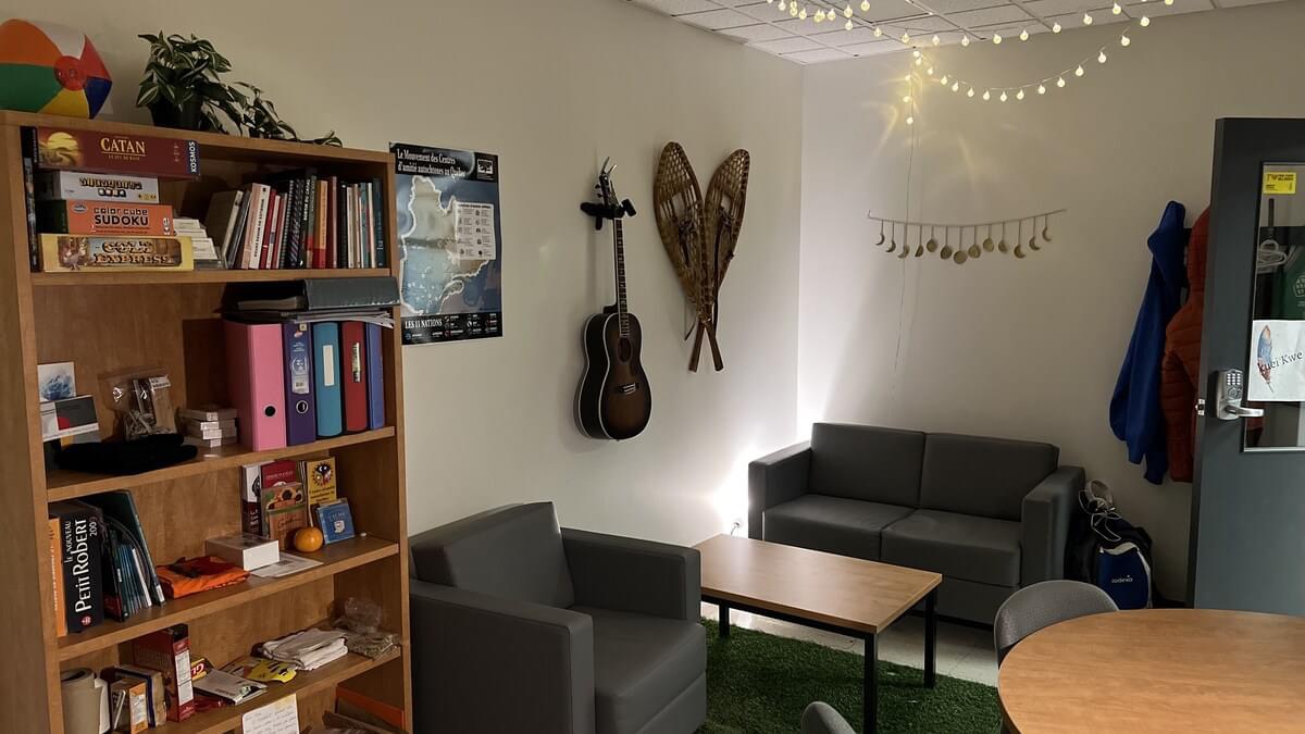 local aménagé avec décor autochtone, tables, sofas et bibliothèque garnie de livres