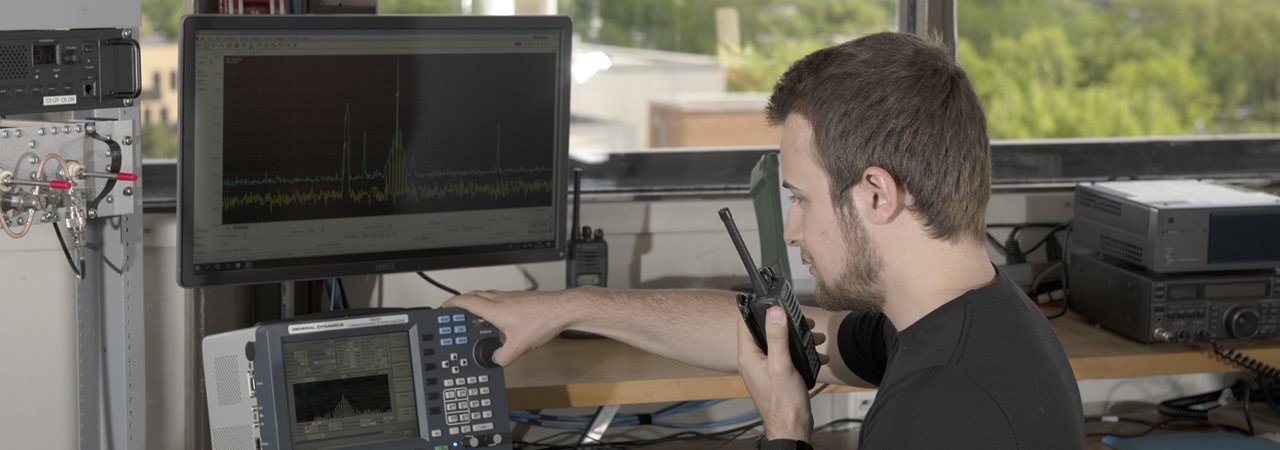 Étudiant faisant fonctionner un système de télécommunication dans la tour de contrôle et parlant dans un walkie-talkie
